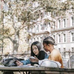 Diverse female students preparing for exams together in city park